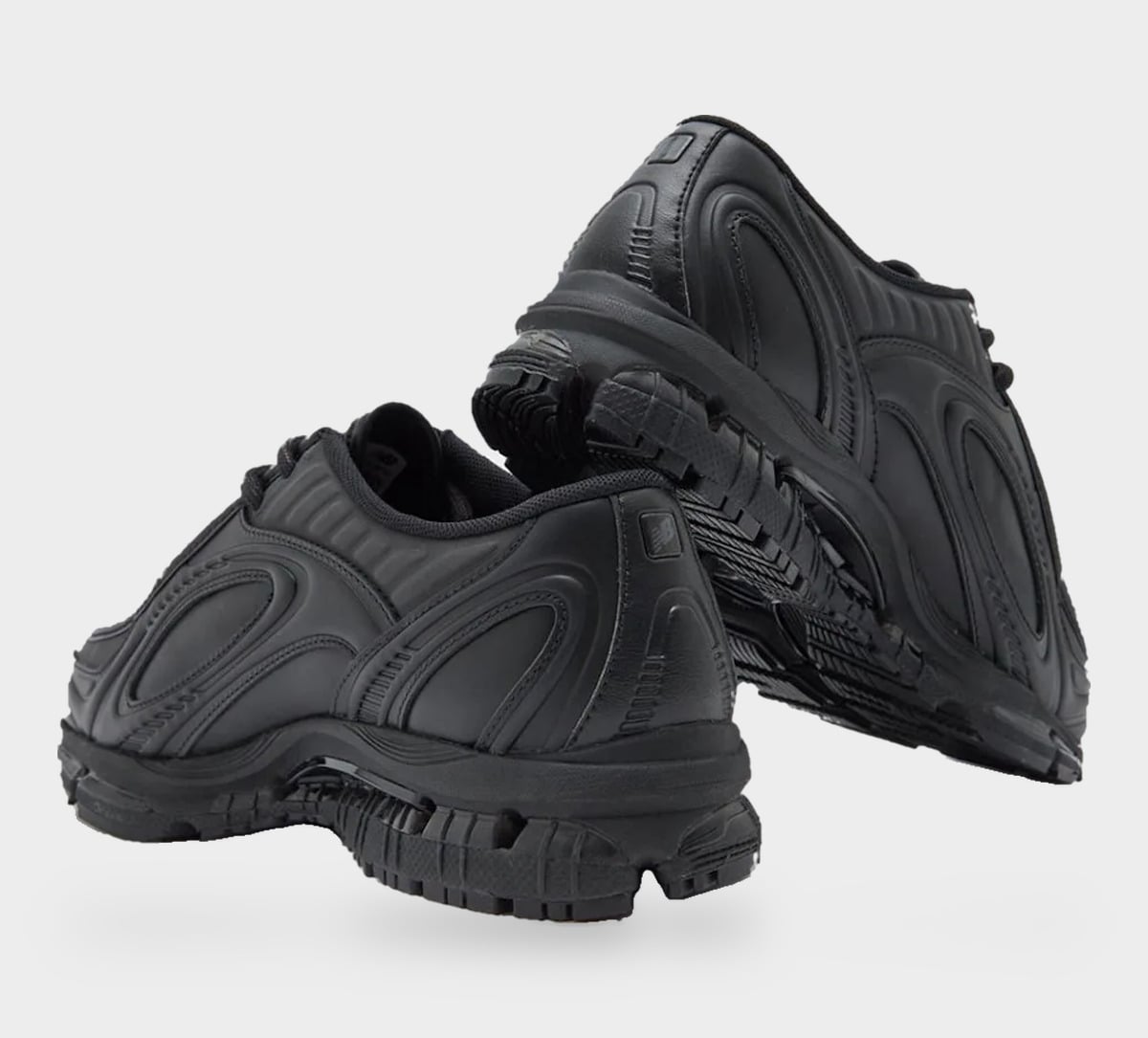 Heel view of pair in black leather with raised swirling overlays and small logo on heel tab, Black Leather