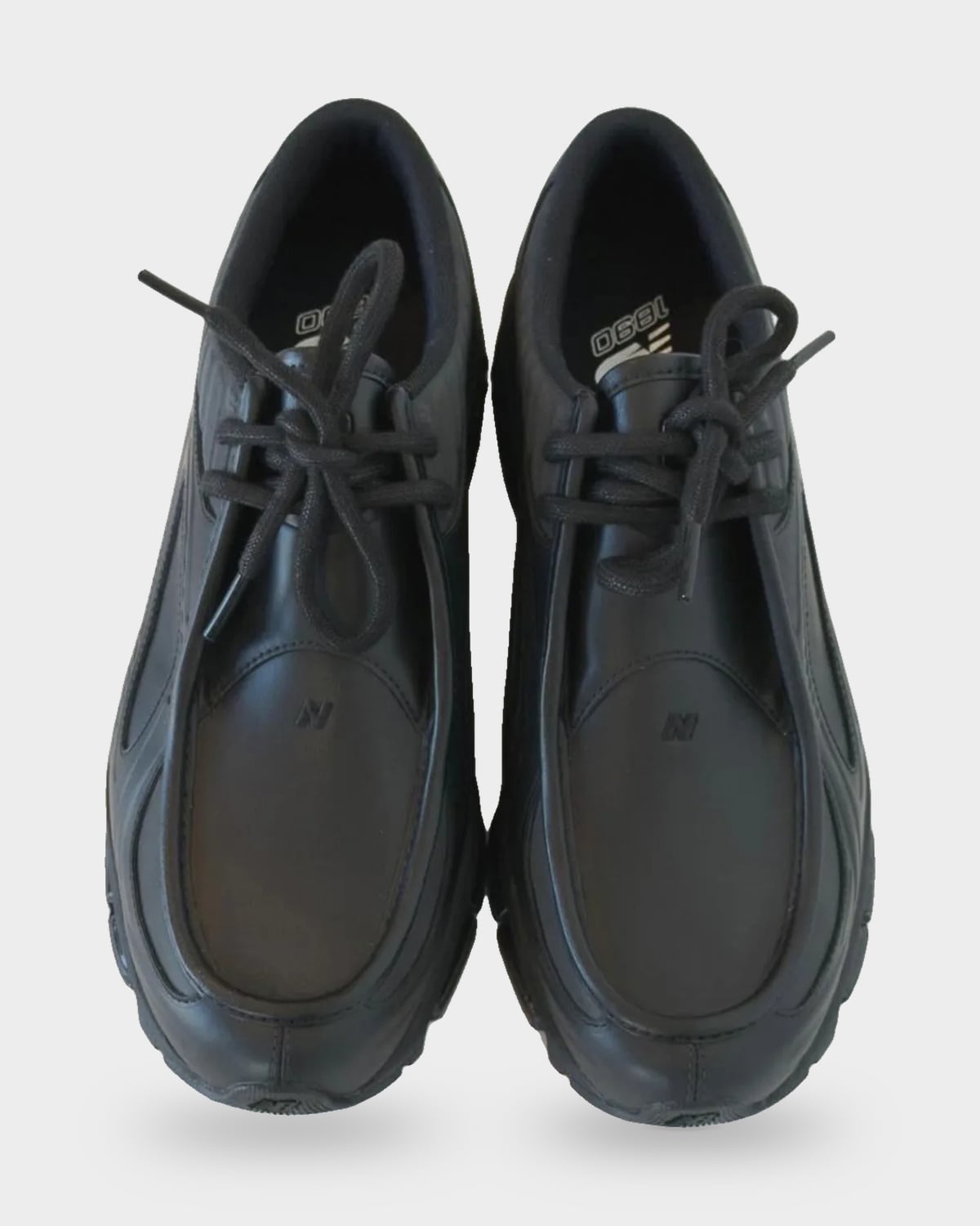Top-down view of pair with black laces, smooth black toe panels and 1890 insole print, Black Leather
