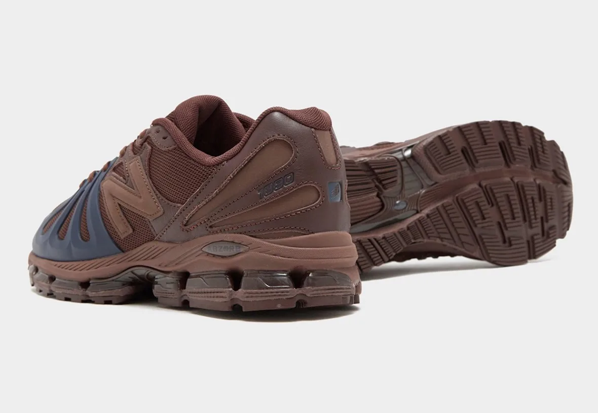 Brown sneaker with navy toe seen from the heel, other shoe turned over showing the tread outsole, Brown/Navy