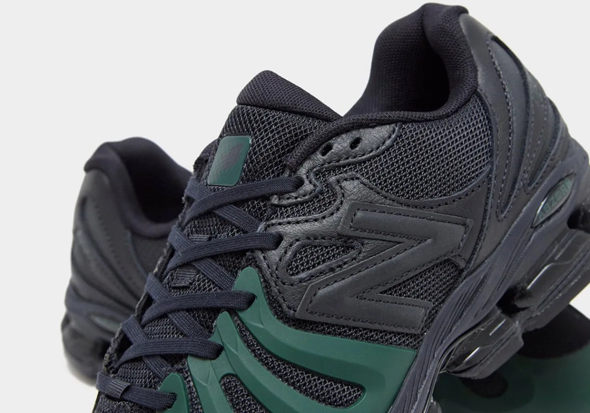 Detail of black sneaker tongue and laces with green tag, black N logo and green toe overlay, Brown/Navy