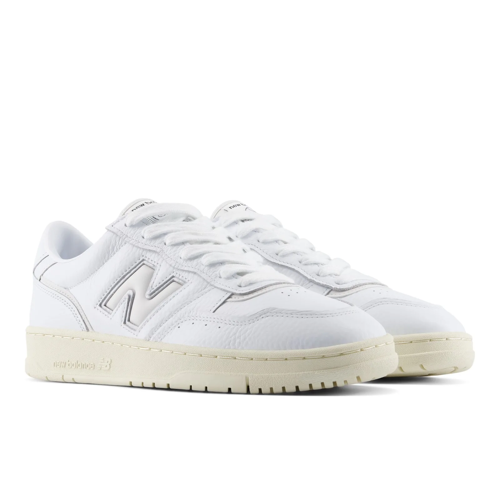 Pair at three-quarter angle, white laces, grey N logo, cream midsole with new balance text, White/Angora