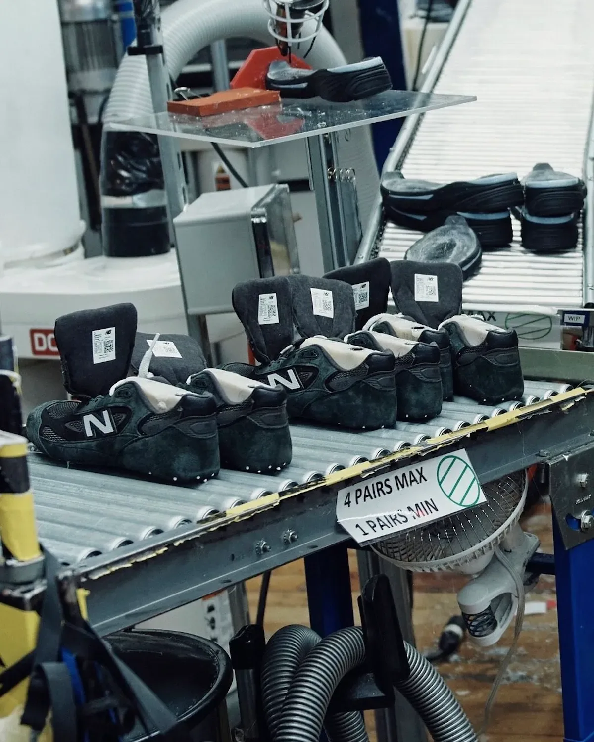 Unfinished shoes on factory rollers, with upright tongues and white N logos, Black