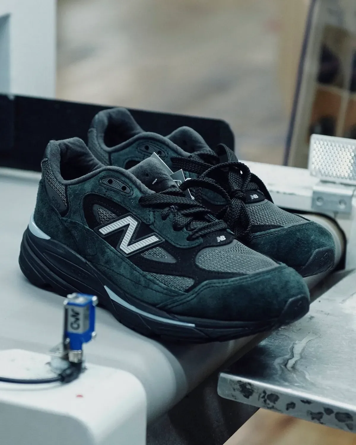 Pair on a workbench with dark suede, grey mesh and white N logos, Black