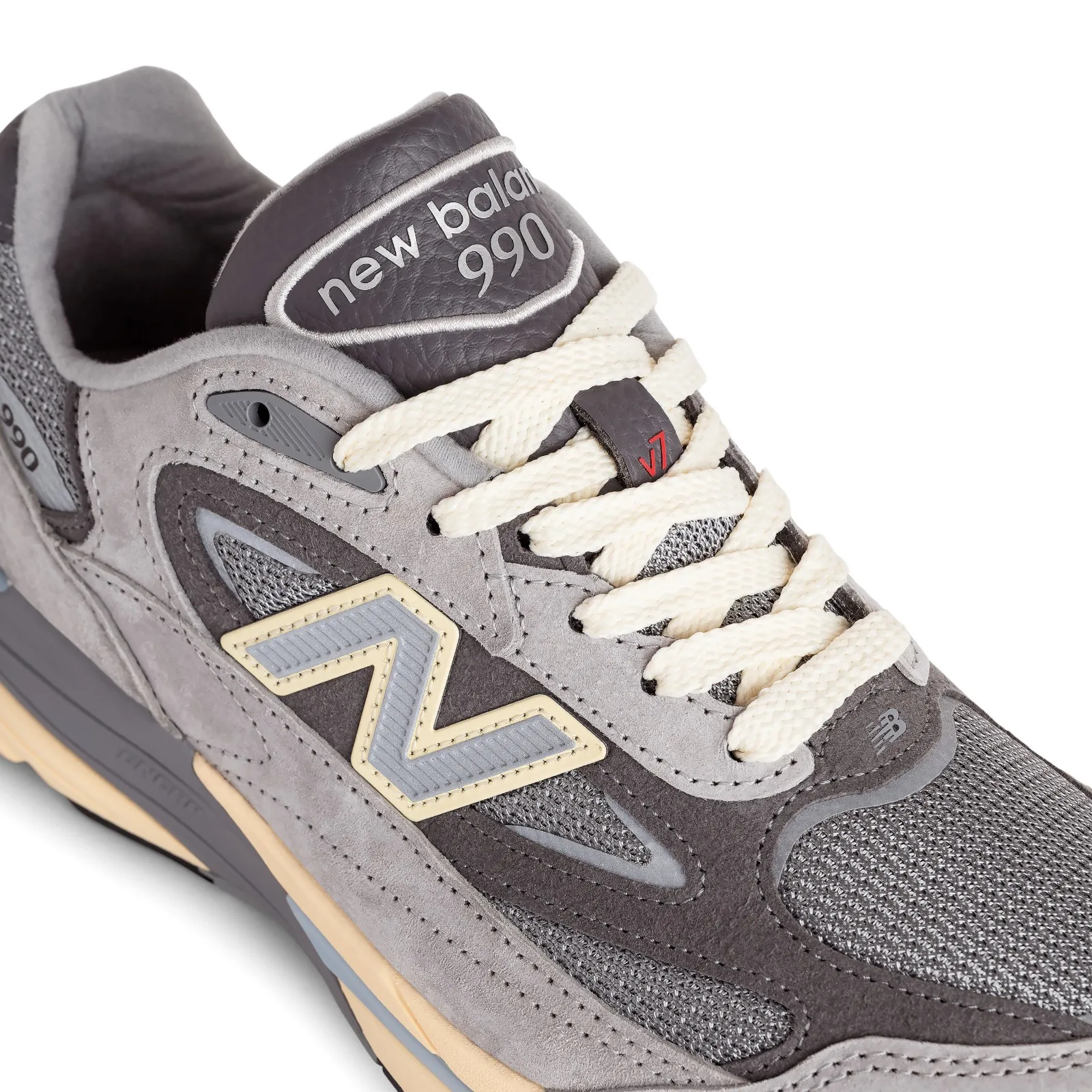 Close-up of laced collar with cream laces, N logo, 990 tongue and red v7 mark, Kool Grey