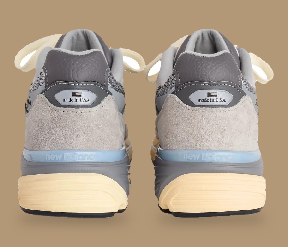 Heel view of pair with made in U.S.A. tabs and light blue new balance heel band, Kool Grey