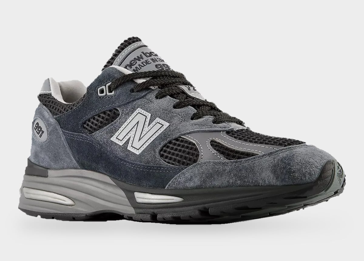 Three-quarter toe view of single shoe, grey suede toe, black mesh, grey N logo, Turbulence/India Ink