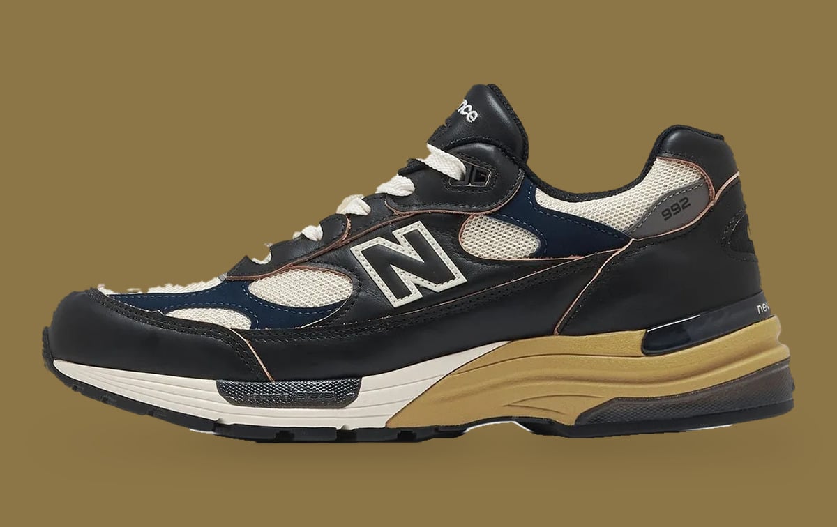 Lateral view on tan background, black leather upper with cream mesh, navy panels and large N logo, Afterglow