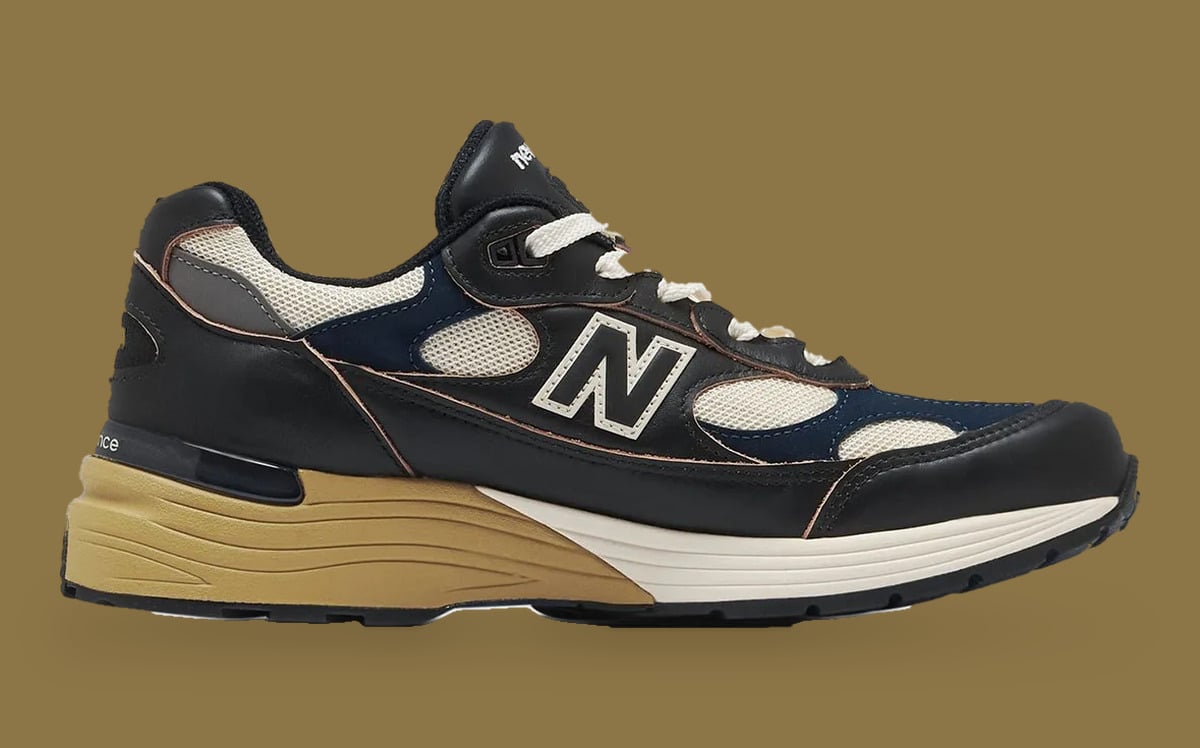 Medial view on tan background, black leather with cream mesh, navy overlays and N logo, Afterglow