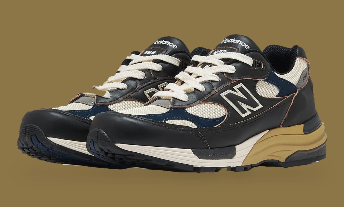 Pair at three-quarter angle on tan background, cream laces, black leather, navy and cream mesh, Afterglow