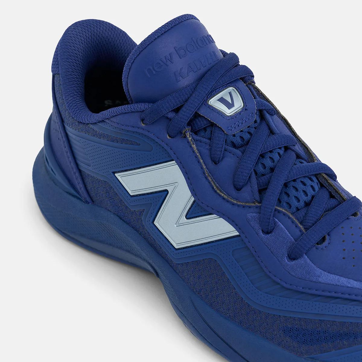 Detail of blue collar and midfoot with pale blue N, V badge on tongue and Kawhi tongue text, Balance Kawhi 5