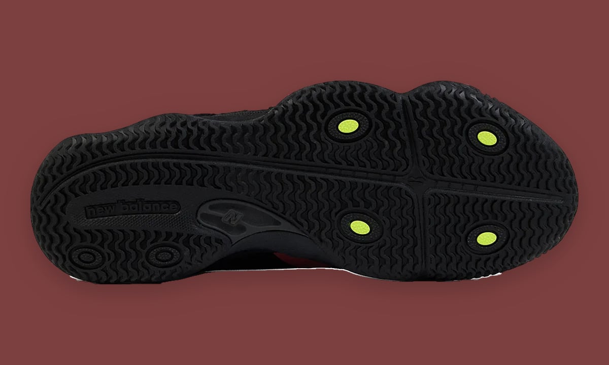 Outsole view, black wavy tread with four lime green circles, new balance text, Red Rock