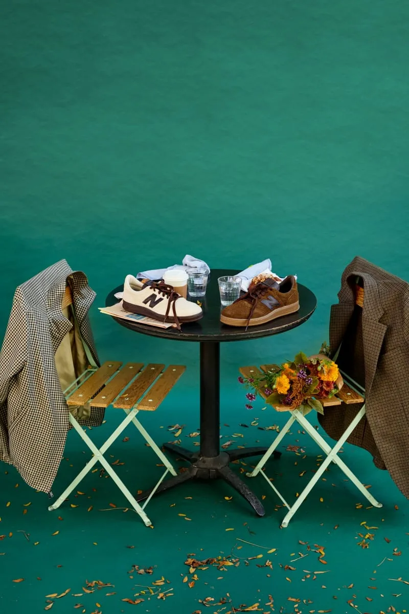 Cream and brown suede sneakers on a round cafe table with coffee, flowers and jackets on chairs, Café