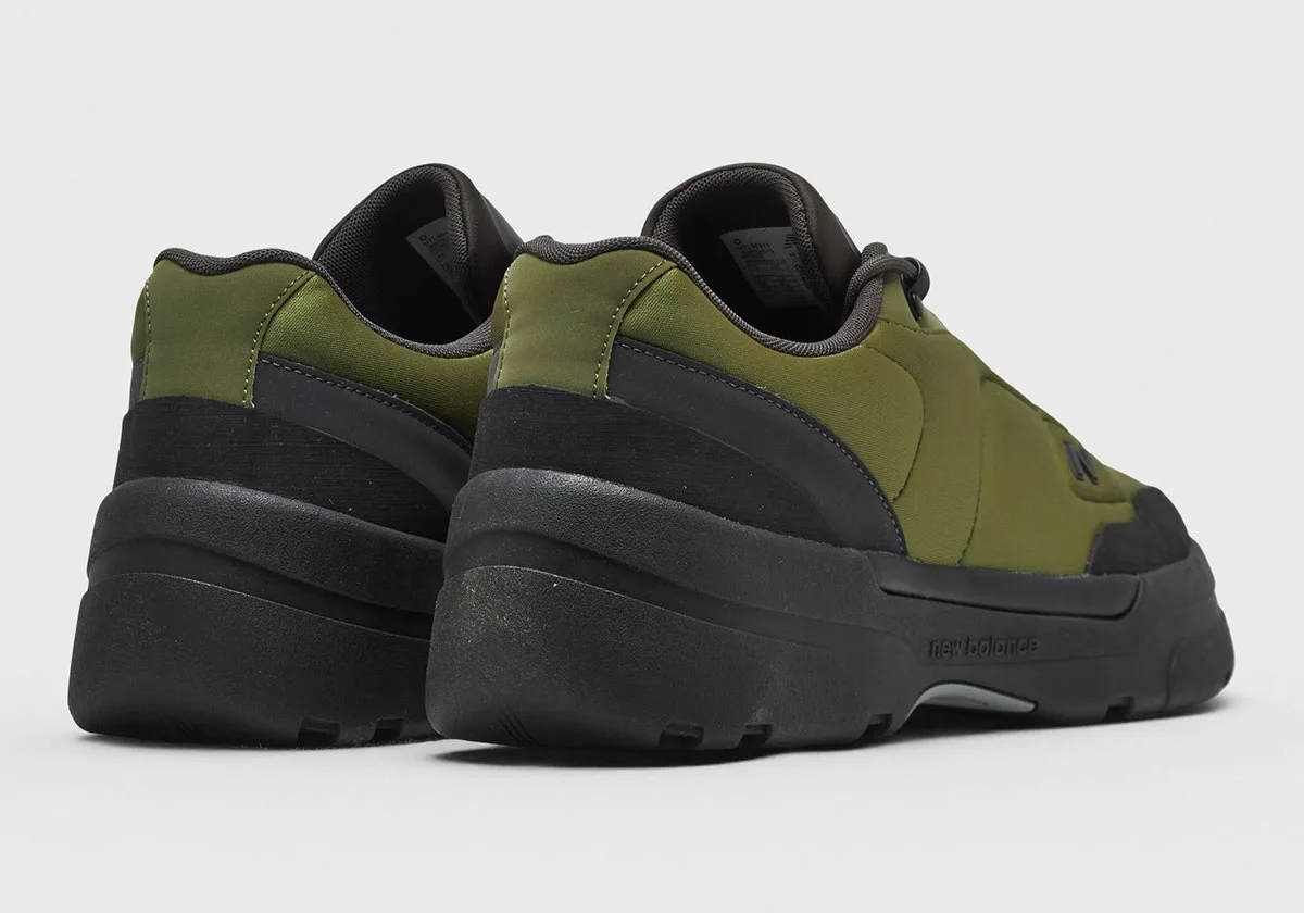 Heel and rear view of pair: olive upper, black heel overlay, chunky black sole with New Balance text, Sport Green/Black