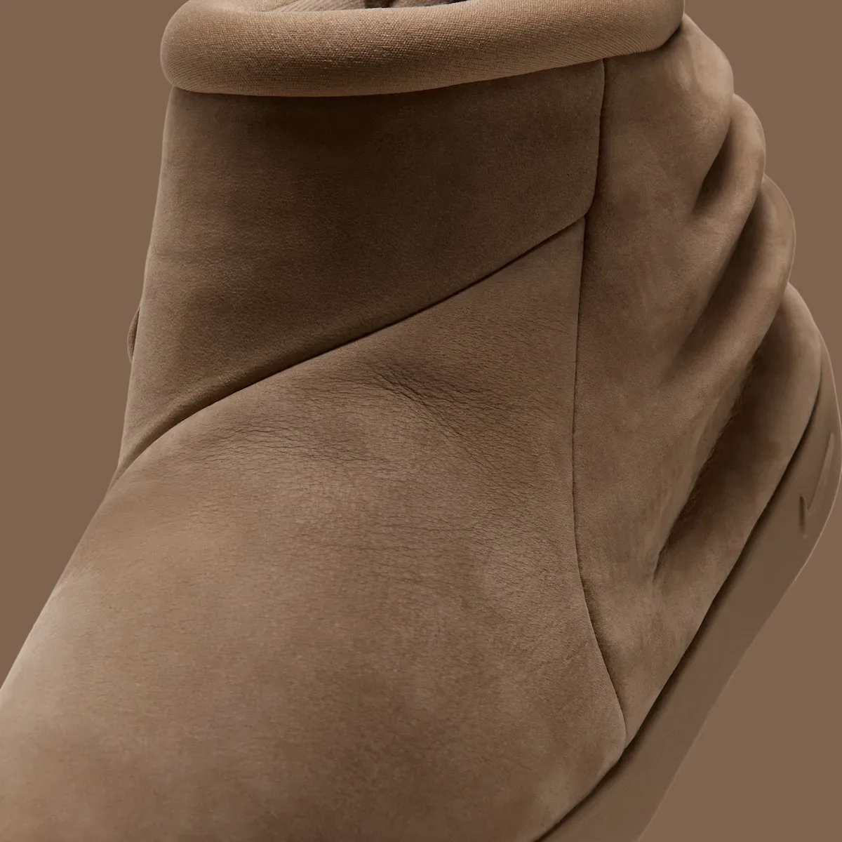 Close-up detail of brown nubuck panels, seam and padded collar on brown backdrop, Dark Driftwood