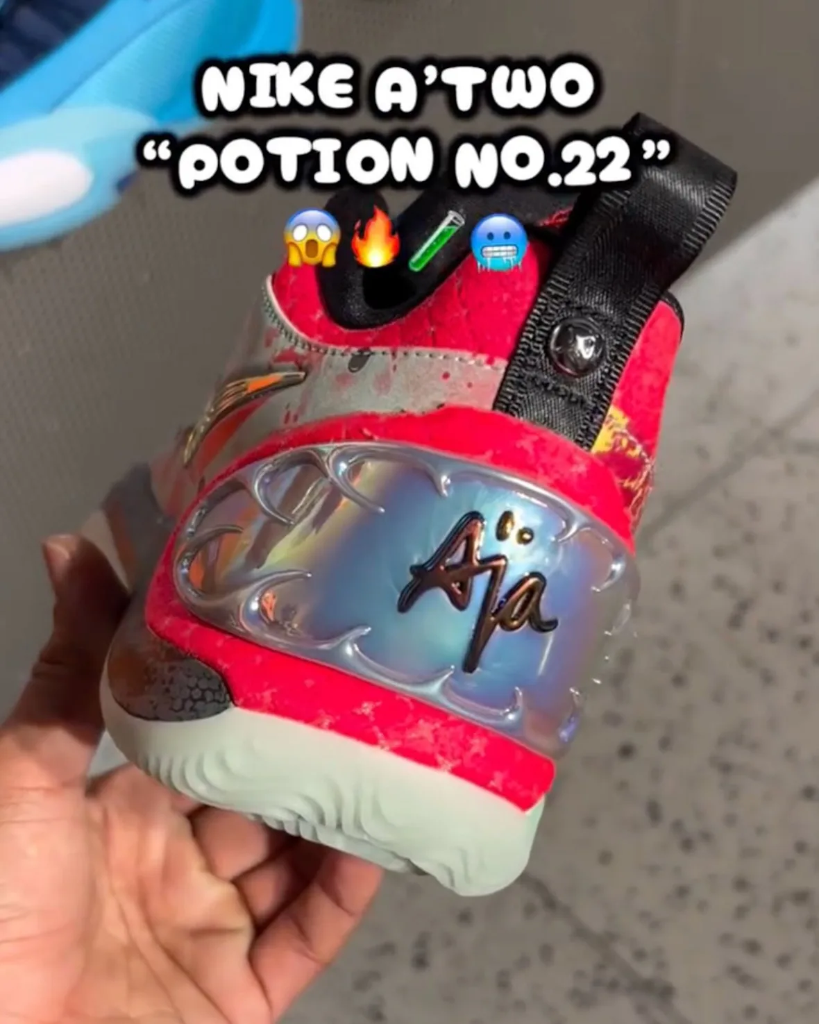 Heel view in hand showing iridescent silver-blue heel pod with script lettering, hot pink collar and black pull tab, Potion