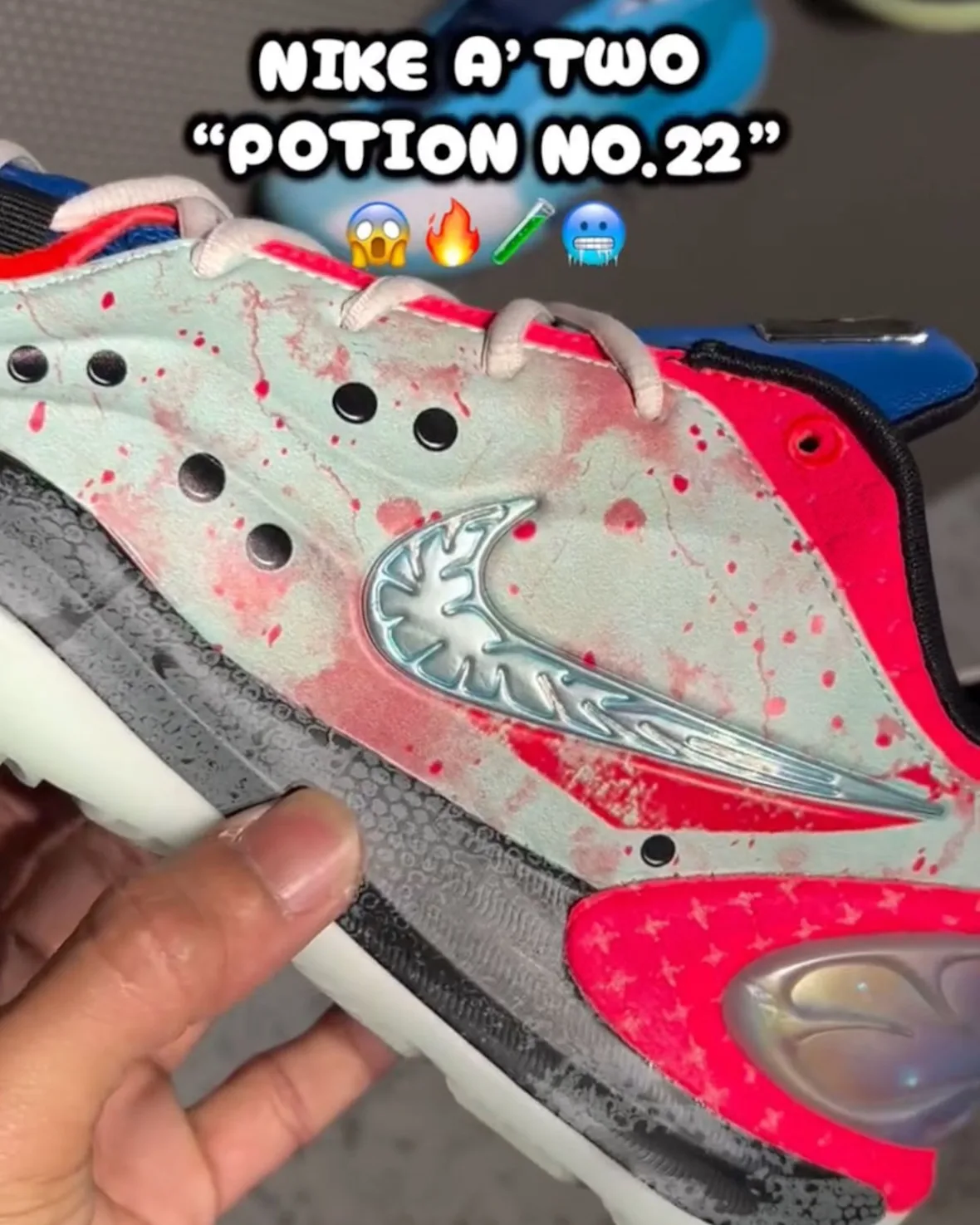 Close-up of metallic silver-blue swoosh on mint upper with red splatter, hot pink heel and iridescent heel pod, Potion No. 22