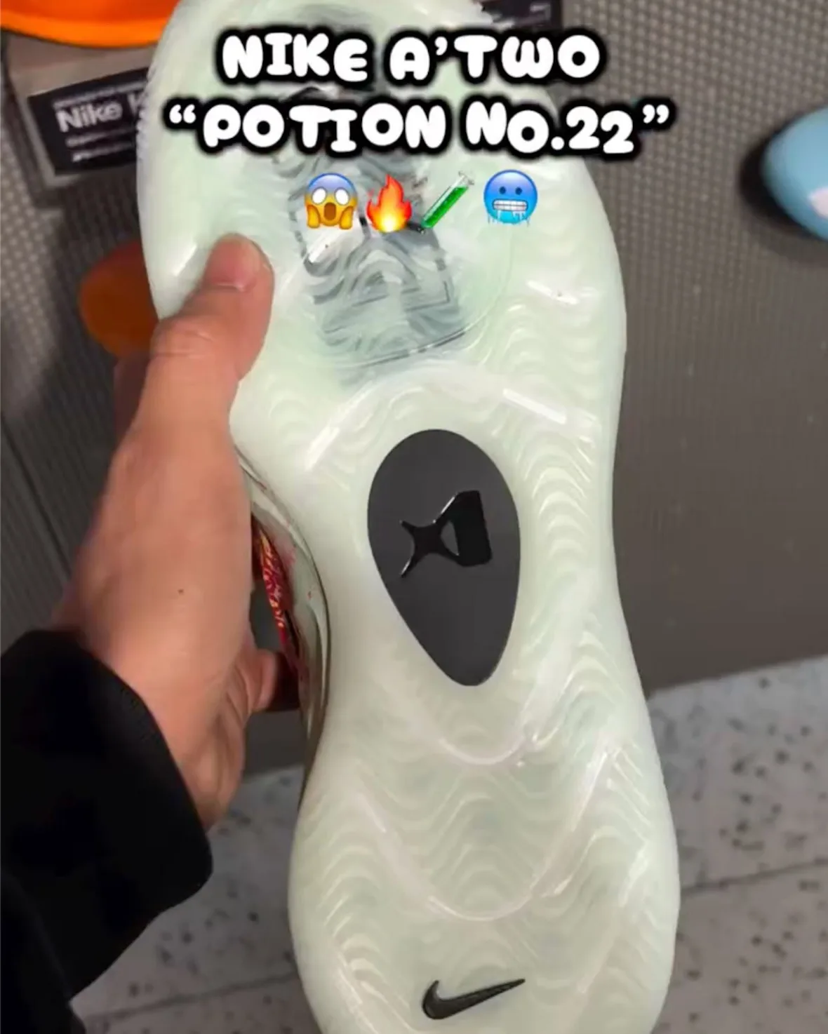 Outsole in hand, translucent mint-green with wave tread, dark grey oval pod and black Nike swoosh near heel, Potion No. 22
