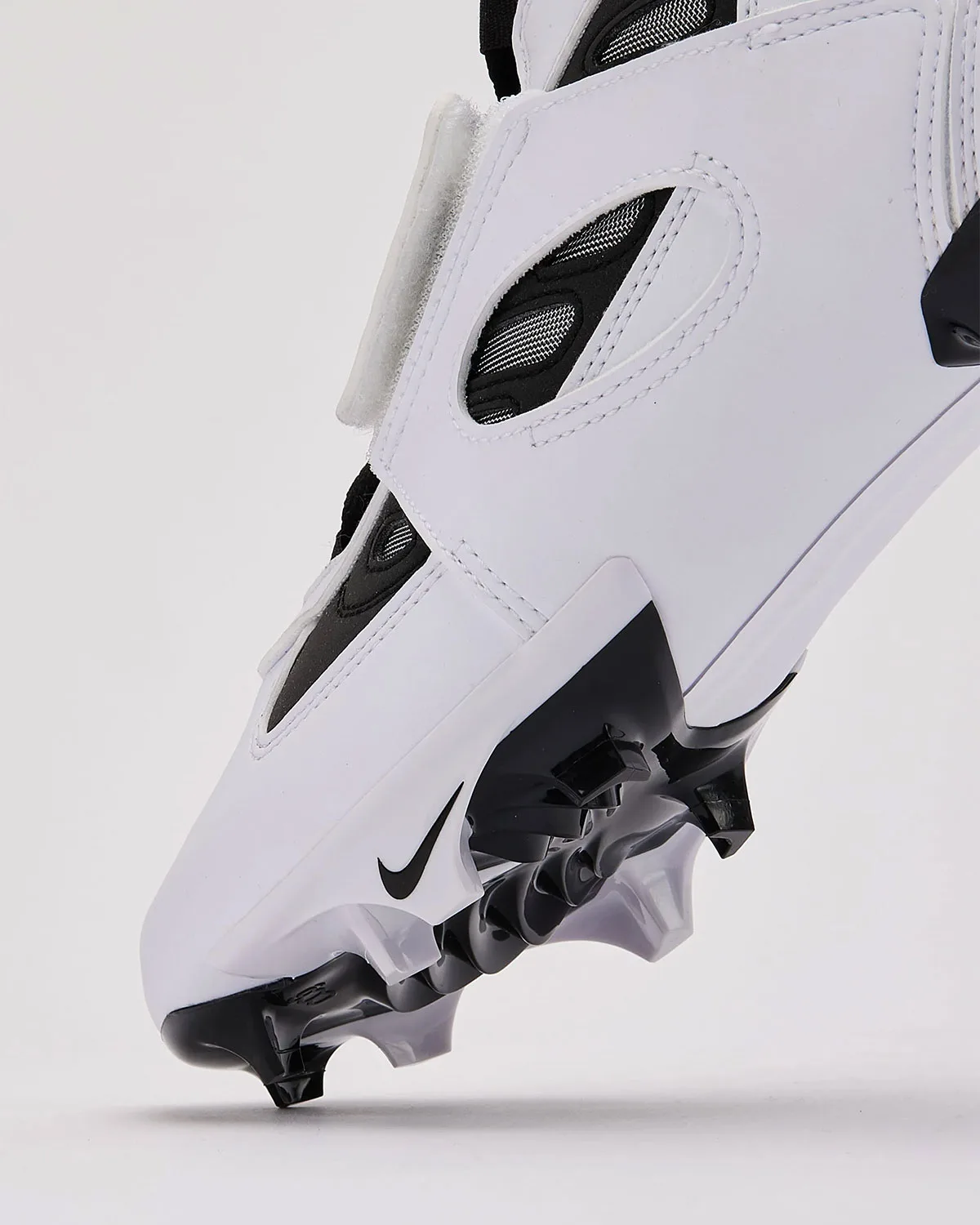 Angled toe detail, white leather upper with black Swoosh, mesh-backed cutouts and black studs, White/Black