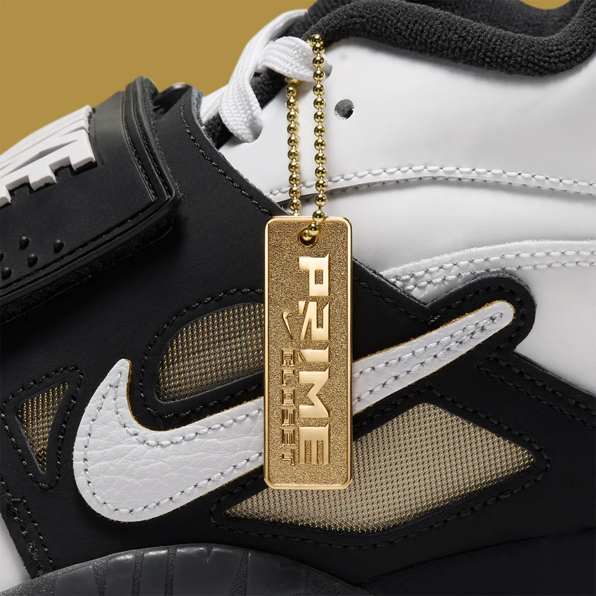 Detail of gold chain tag reading Prime Closet, hung on white and black shoe with swoosh, White/Black