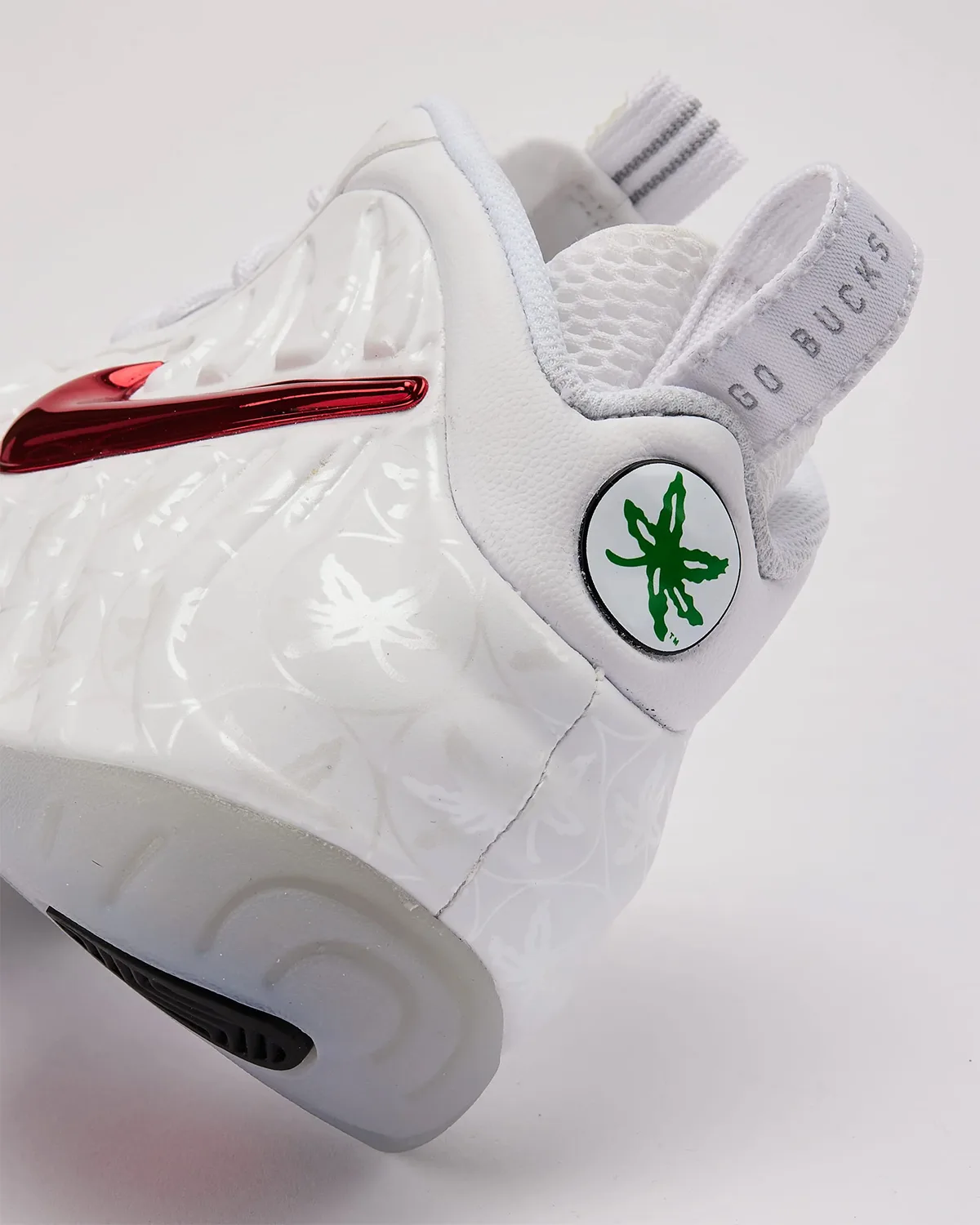 Heel detail, green buckeye leaf badge and "Go Bucks" pull tab on white shoe, Ohio State