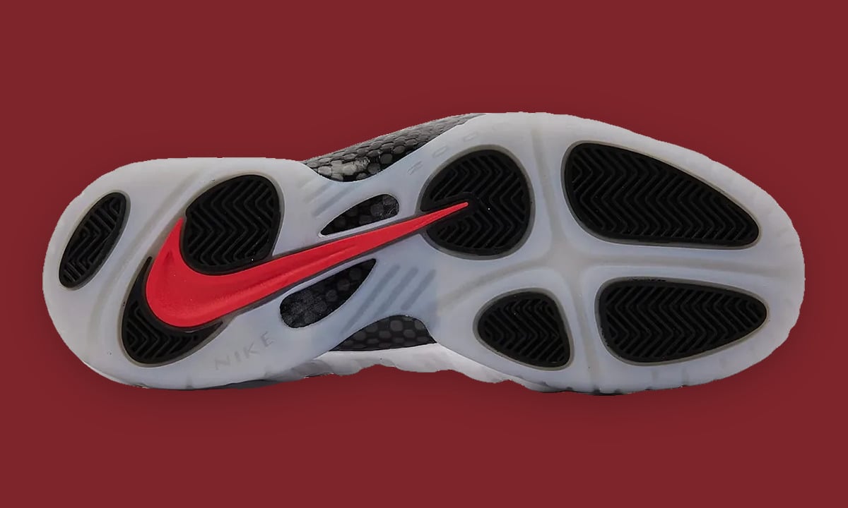 Outsole, translucent icy sole with black pods and red swoosh on maroon background, Ohio State