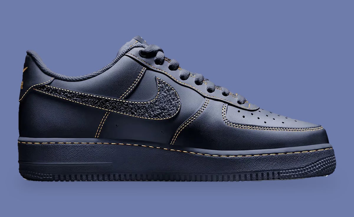 Medial view, navy leather with gold stitching and textured fuzzy swoosh on lavender background, Milwaukee Brewers