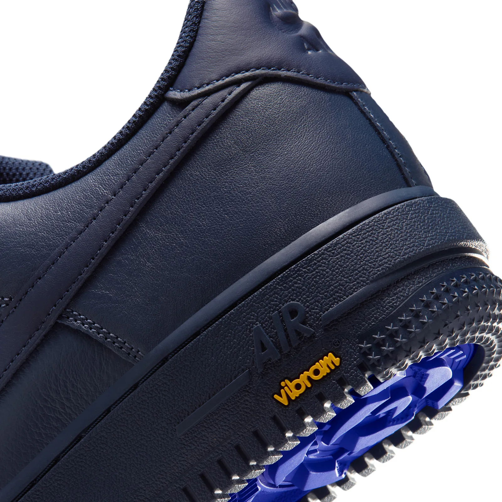 Detail of heel with raised AIR text, yellow Vibram logo and blue outsole peeking out, Thunder Blue