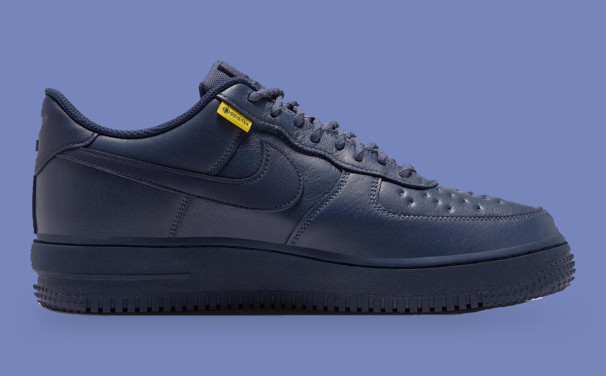 Medial view of navy leather sneaker with yellow Gore-Tex tab and perforated toe, Thunder Blue