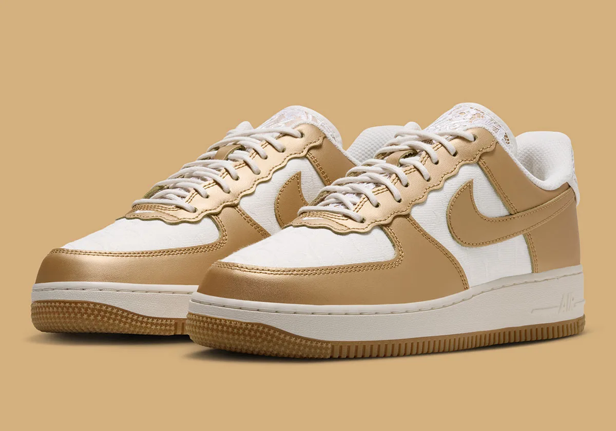 Pair at three-quarter angle on tan background, scalloped gold eyestays, cream laces, Lace
