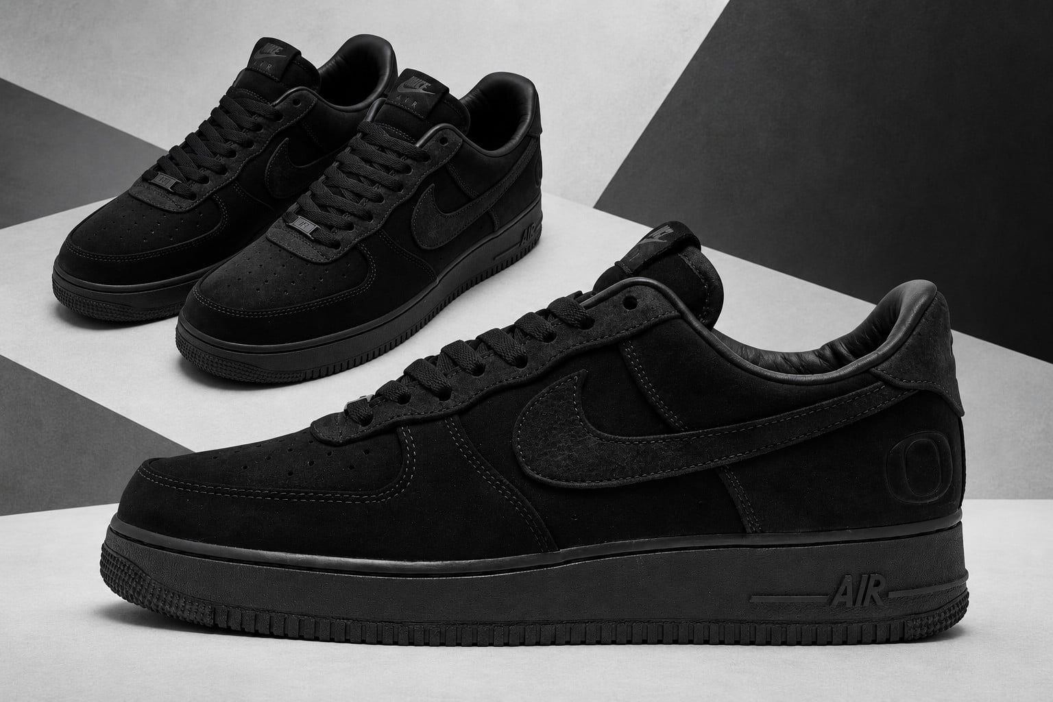 Lateral view and angled pair in black against a grey geometric backdrop, Nike Air Force 1 Low x Oregon “Triple Black”