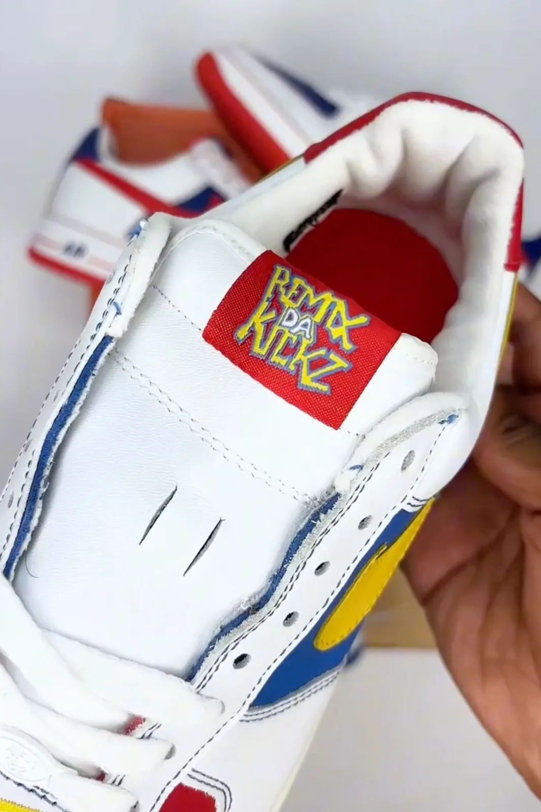 close-up of tongue tag reading remix da kickz in yellow lettering on red patch, Remix Da Kickz