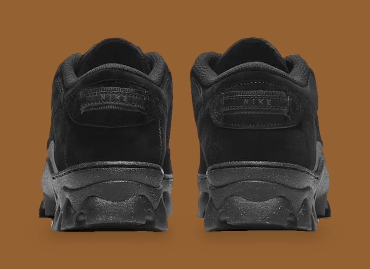 Heel view of black suede pair with tonal NIKE pull tabs and speckled black soles, Black