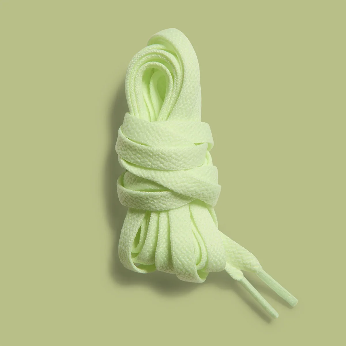 Detail of bundled pale green spare laces on a green background, Glow In The Dark Safari