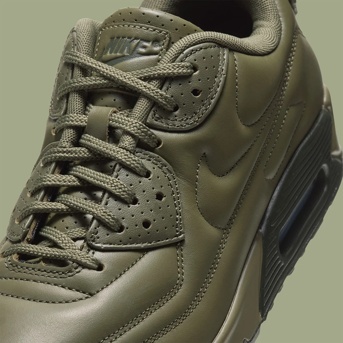 Detail of lacing area, olive leather with perforated panels, tonal swoosh and Nike Air tongue label, Medium Olive