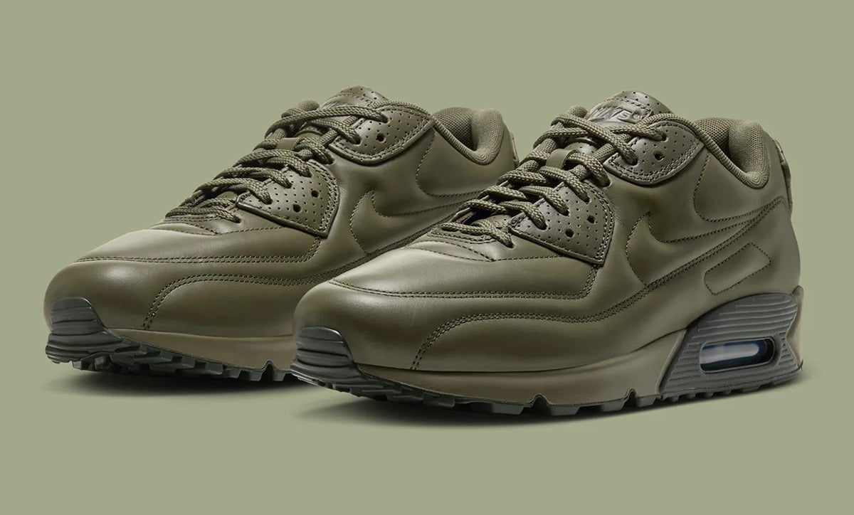 Pair in three-quarter view, olive leather with tonal swooshes and dark Air units, green backdrop, Medium Olive