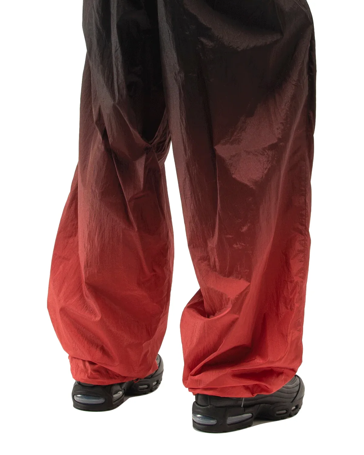 On-foot rear view, black shoes with clear Air units under black-to-red gradient trousers, Black