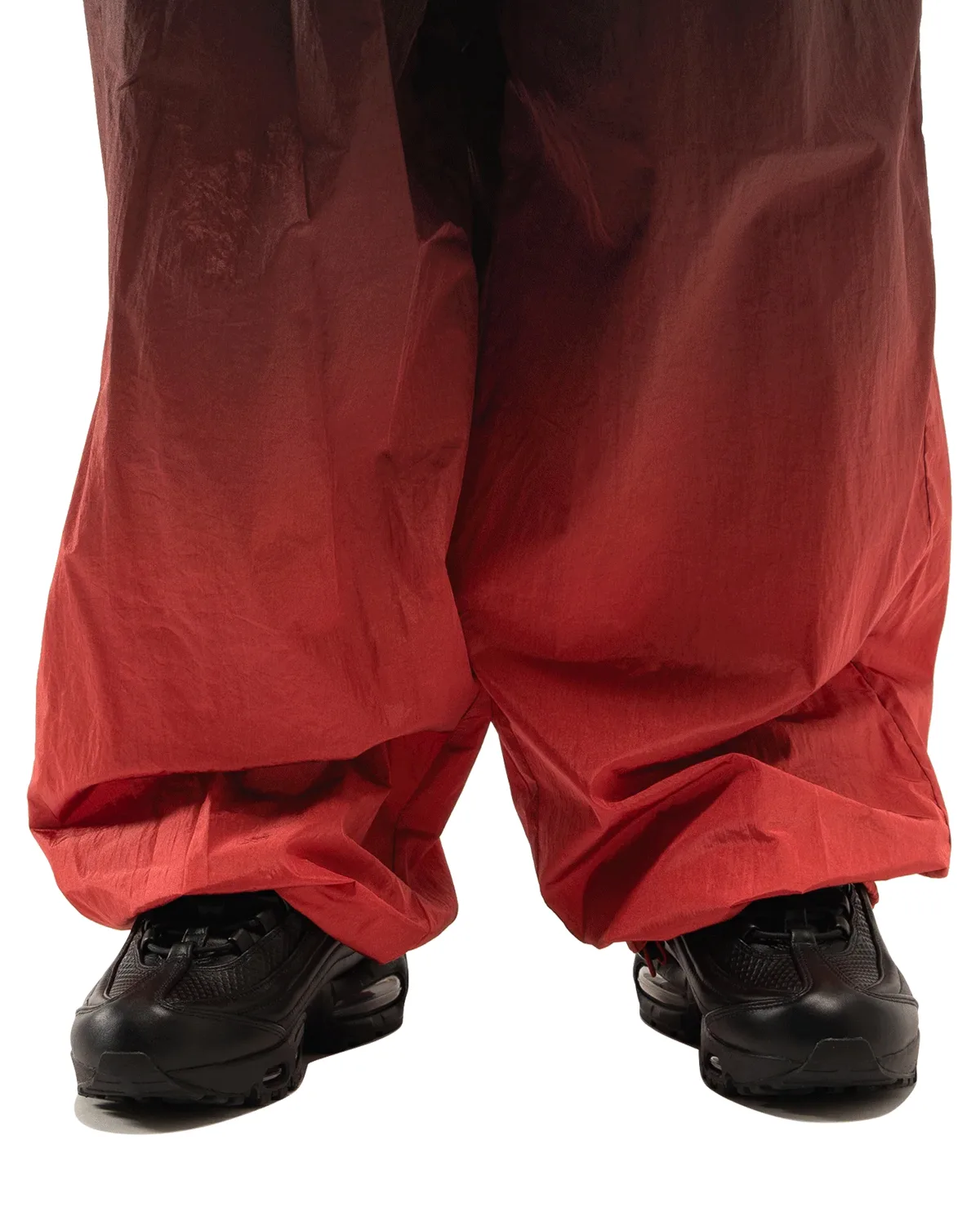 On-foot front view, black leather pair below dark-to-red gradient baggy trousers, Black