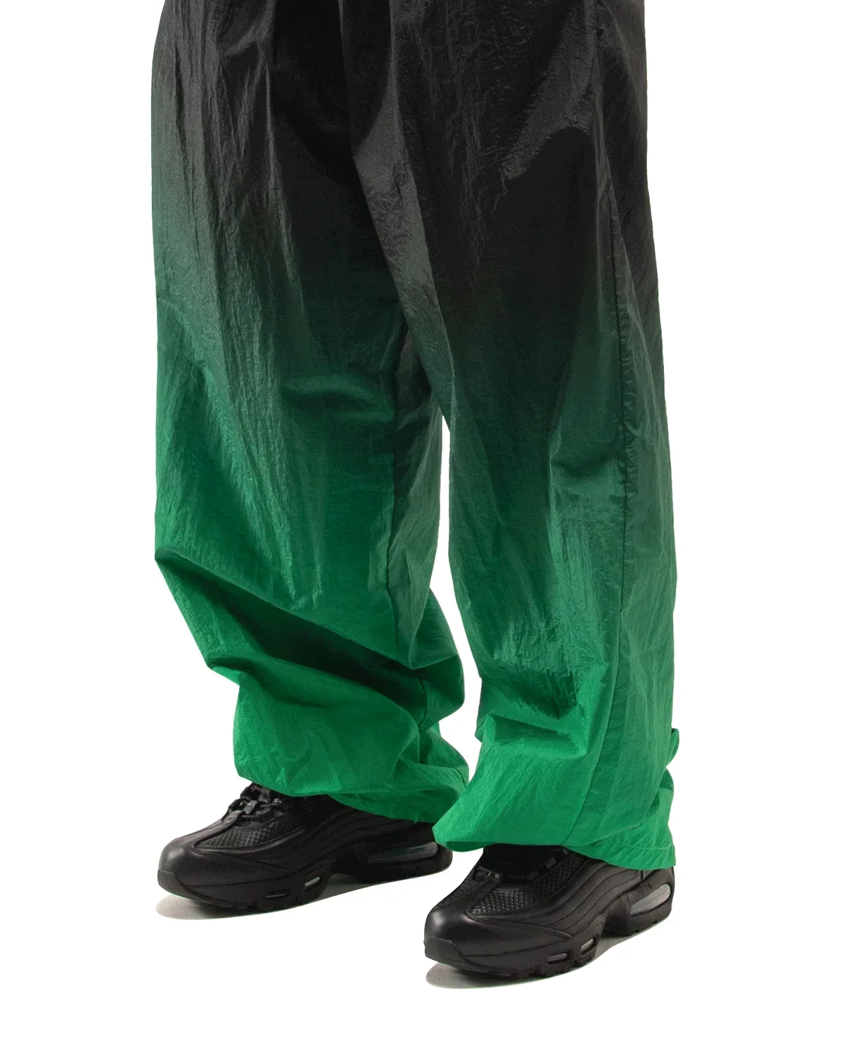 On-foot view, black pair under baggy black-to-green gradient nylon trousers, Black