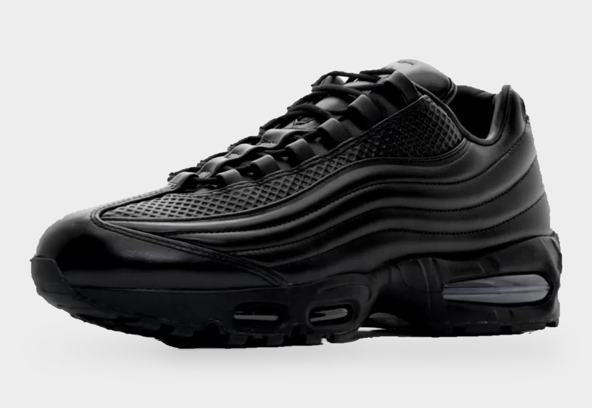 Lateral toe-angled view of all-black leather upper with embossed grid overlays and laces, Black