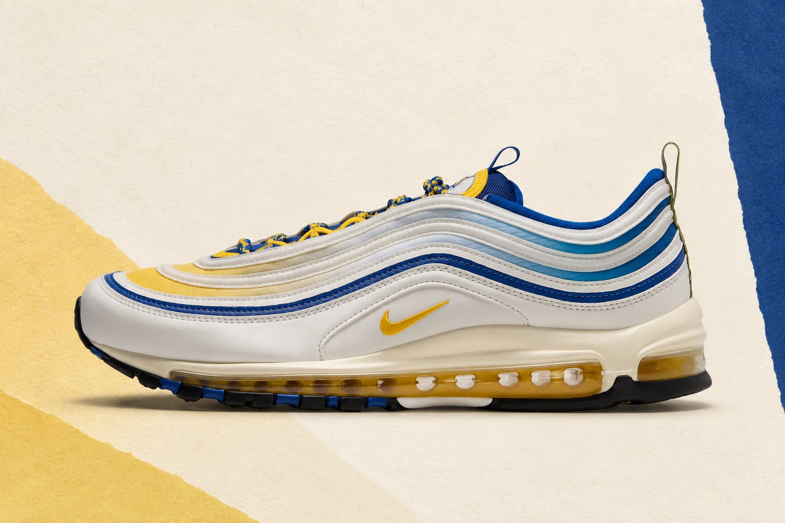 Lateral view with white wavy overlays and blue and yellow accents, Nike Air Max 97 “NC A&T”