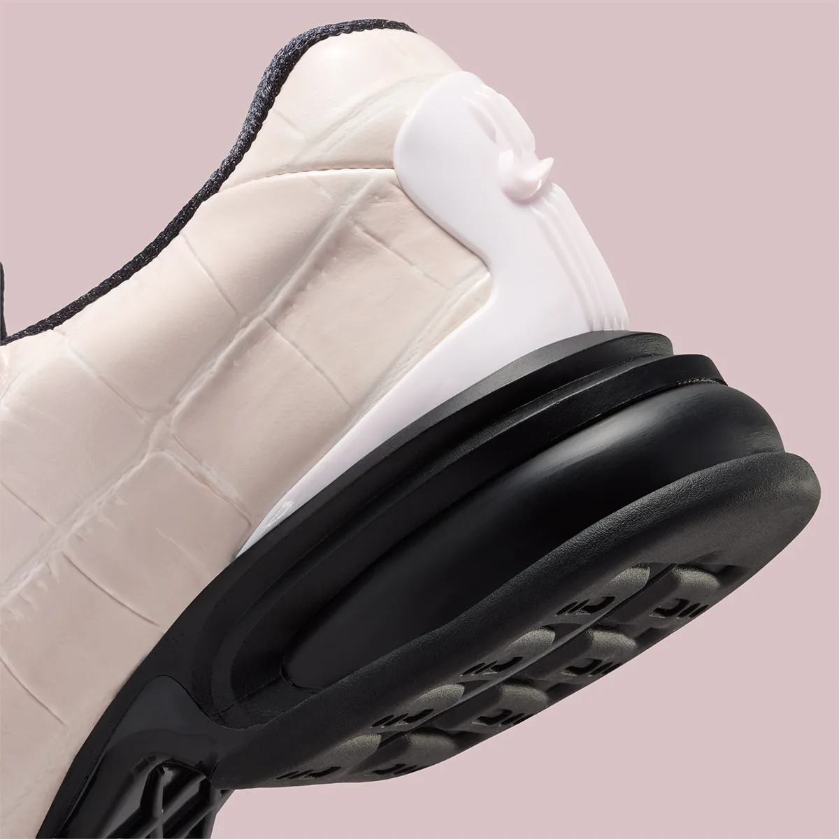 Heel detail, pale pink croc panels, white heel clip with Swoosh, black sole, pink backdrop, Pearl Pink