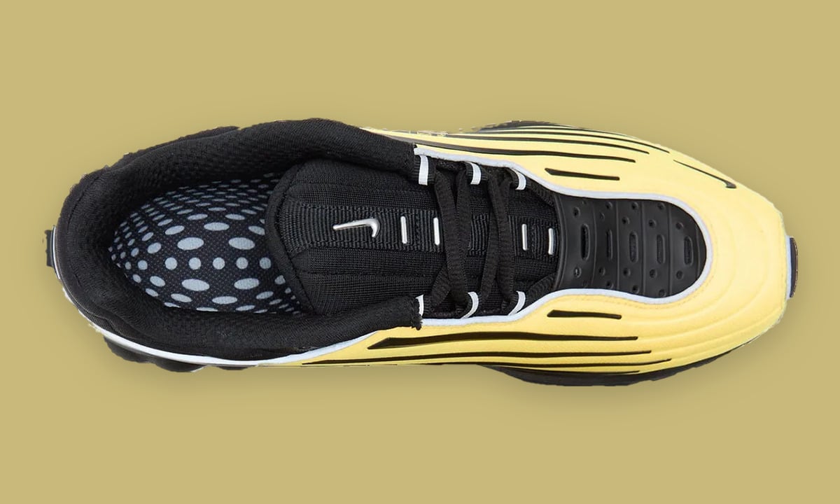 Top-down view of one shoe, black laces and tongue, dotted grey insole, yellow side, Citron