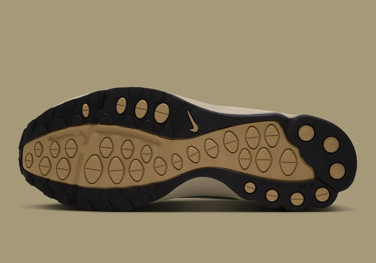 Outsole view with black rubber and tan oval lugs, small tan Nike swoosh near the arch, Desert Khaki