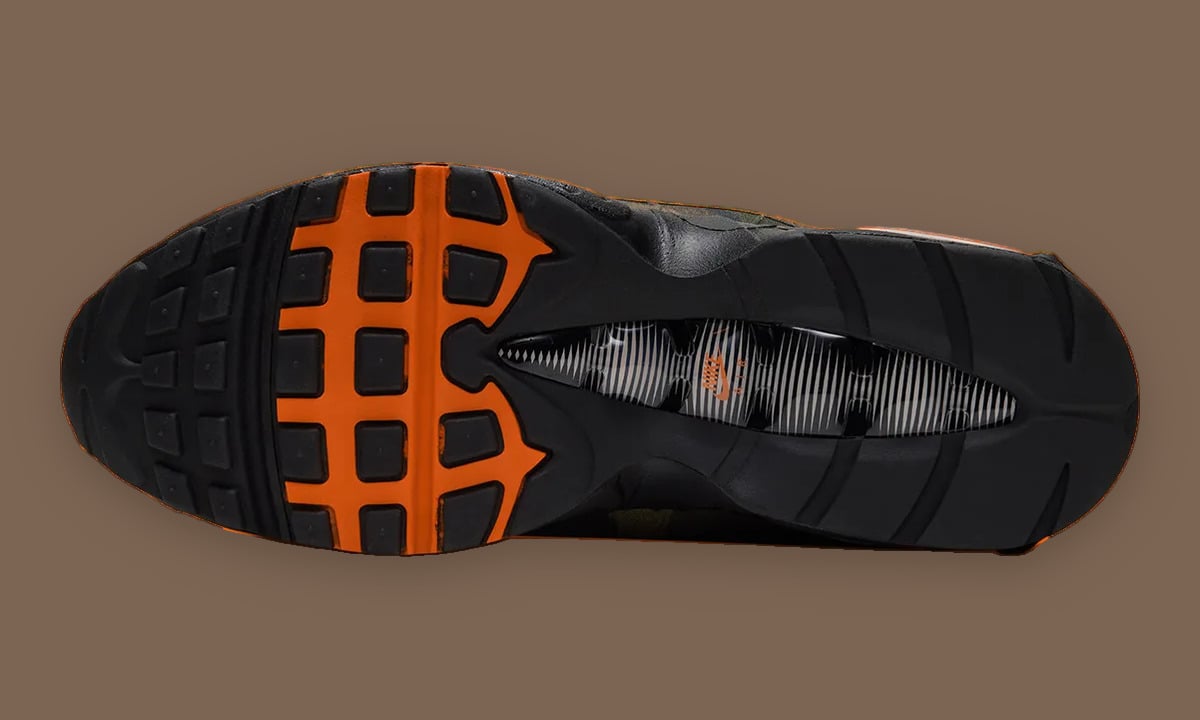 Outsole view with black tread, bright orange sections and a striped midfoot, Camo