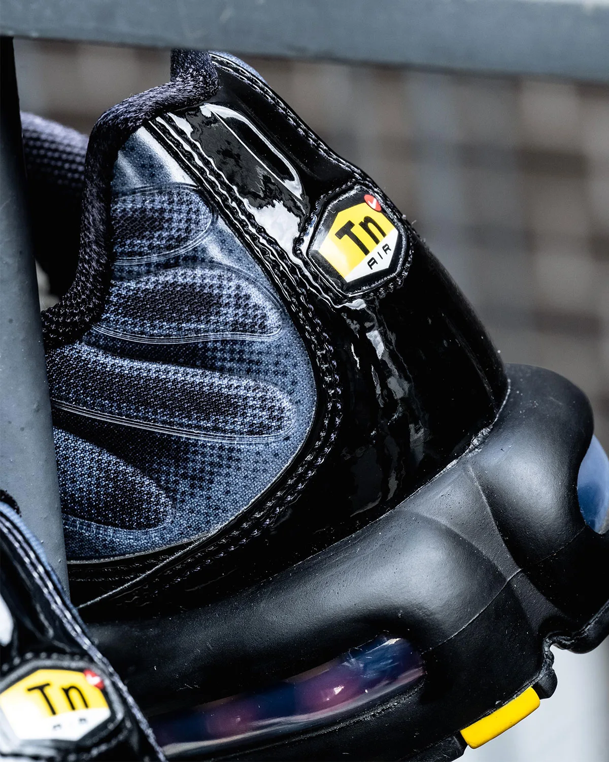 Heel detail with yellow and black Tn Air badge, black patent overlay and blue-grey mesh, Black/Cool Grey