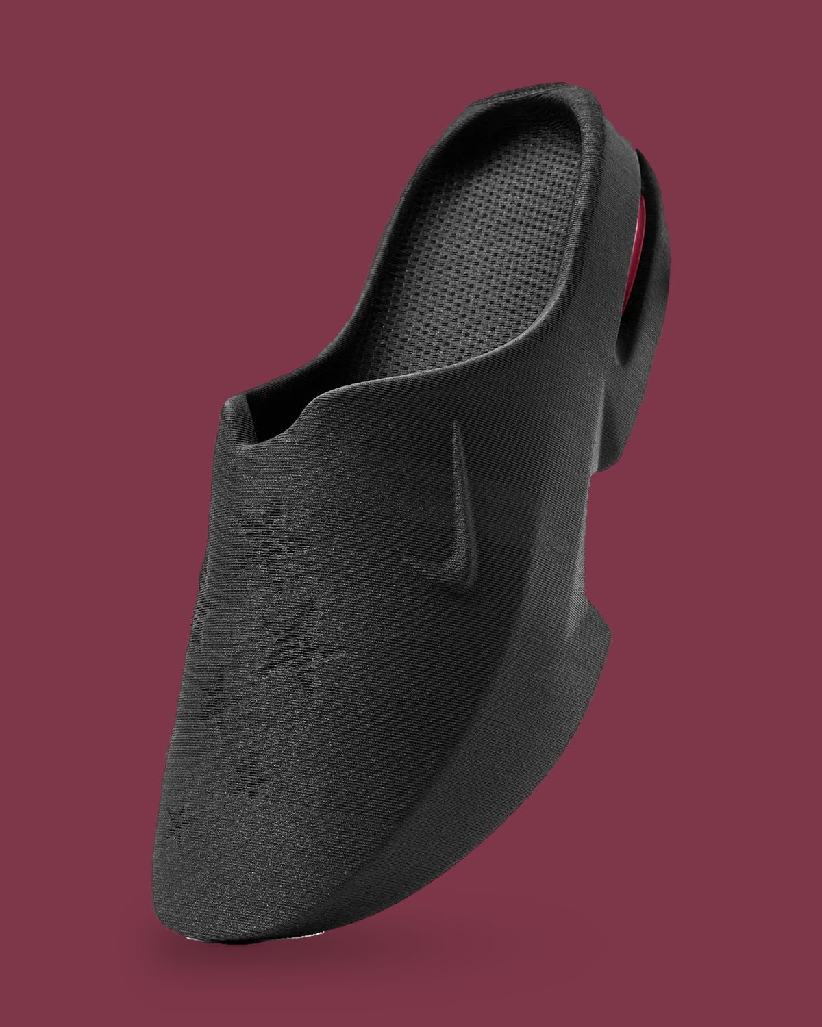 Angled black mule on maroon with ribbed texture, embossed stars and Swoosh, pink at heel, Air Max Mule