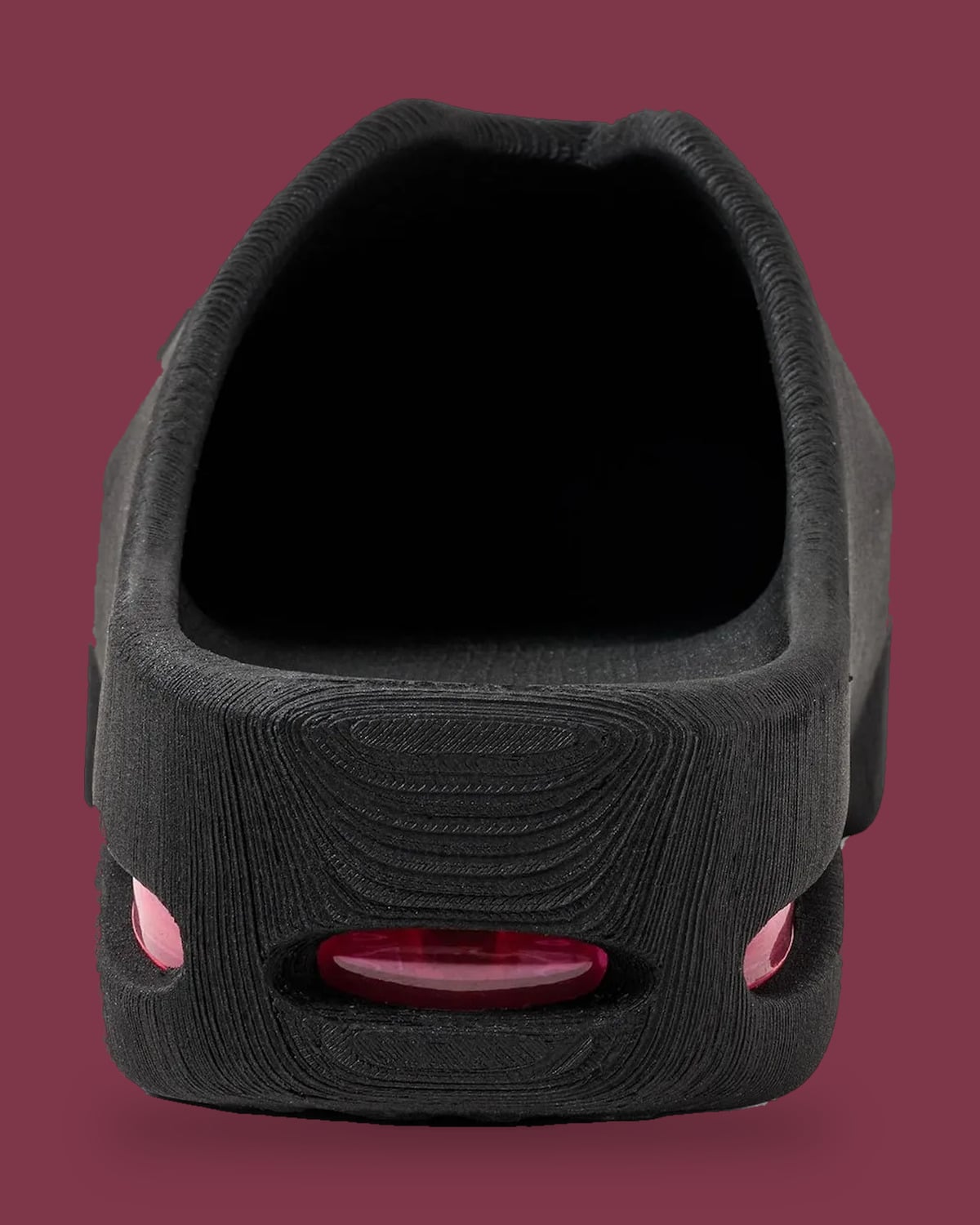 Heel view of black mule with layered texture and pink Air windows, on maroon, Air Max Mule