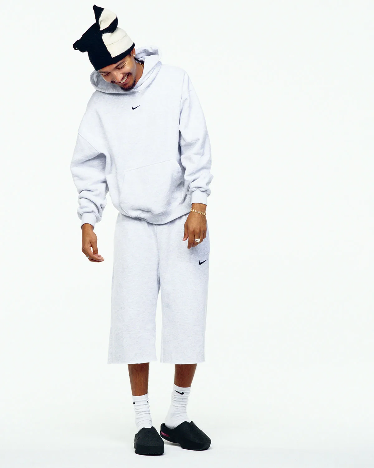 On-foot full-length shot in grey hoodie and shorts, white socks, black mules, on white, Air Max Mule
