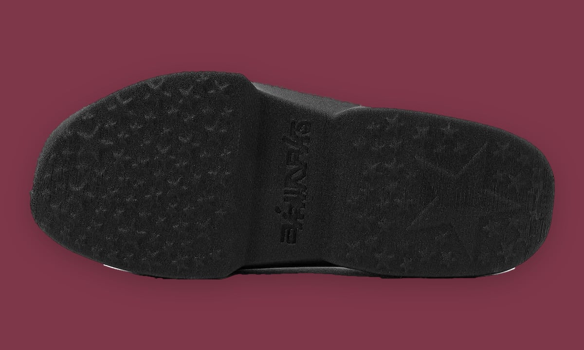 Outsole of black mule with star-pattern tread and embossed text, on maroon, Air Max Mule