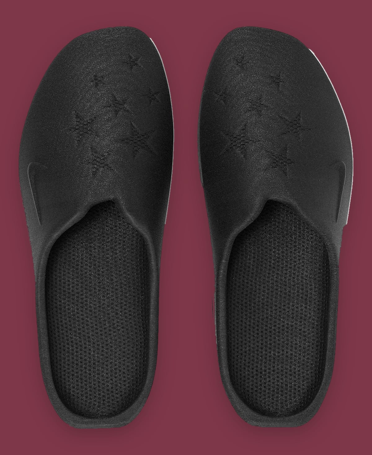 Top-down view of two black mules with mesh footbeds and embossed stars, on maroon, Air Max Mule